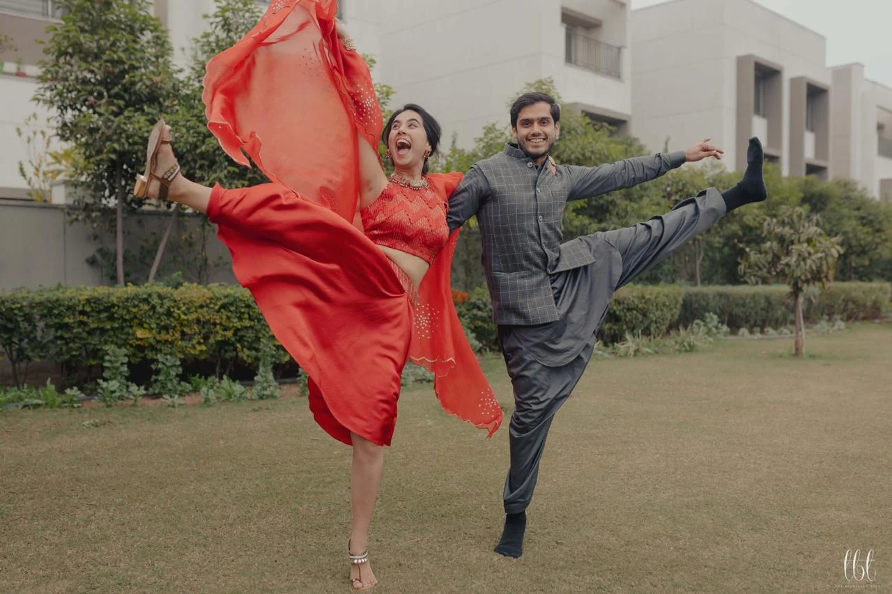 Couple dancing in bright red and charcoal outfits
